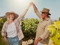 Smiling senior couple dancing together and feeling playful on vineyard. Caucasian husband and wife standing together and Royalty Free Stock Photo
