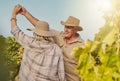 Smiling senior couple dancing together and feeling playful on vineyard. Caucasian husband and wife standing together and Royalty Free Stock Photo