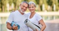 Smiling senior couple husband and wife embracing while standing at park with exercise mats Royalty Free Stock Photo