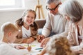 Smiling senior couple grandparents spending time with grandchildren at home on weekend Royalty Free Stock Photo