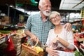 Smiling senior couple holding basket with vegetables at the market Royalty Free Stock Photo