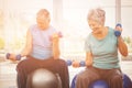 Smiling senior couple holding dumbbells while exercising Royalty Free Stock Photo