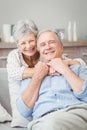 Smiling senior couple hugging while sitting on sofa Royalty Free Stock Photo