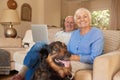 Smiling senior couple relaxing with their dog at home Royalty Free Stock Photo