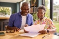 Smiling Senior Couple Sitting Around Table At Home Reviewing Finances Royalty Free Stock Photo