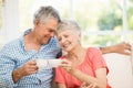 Smiling senior couple toasting with mugs Royalty Free Stock Photo