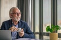 Smiling senior entrepreneur drinking coffee while working on laptop at office Royalty Free Stock Photo