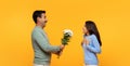 Smiling senior european husband give bouquet of flowers to surprised wife