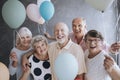 Smiling senior friends with colorful balloons enjoying meeting Royalty Free Stock Photo