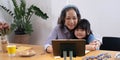 Smiling senior grandma and cute little kid granddaughter watching cartoons on laptop together, happy older grandmother Royalty Free Stock Photo