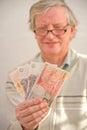 Smiling senior holding winnings. Royalty Free Stock Photo