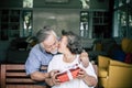 Smiling senior husband making surprise giving gift to his wife