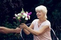 Elderly woman get a beautiful bouquet of field flowers. Royalty Free Stock Photo