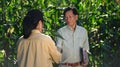 Smiling senior male farmer and female agronomist shaking hands at the cornfield Royalty Free Stock Photo