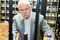 smiling senior man choosing wine bottle at liquor store Royalty Free Stock Photo