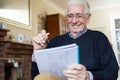 Smiling Senior Man Doing Sudoku Puzzle At Home