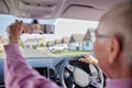 Smiling Senior Man Enjoying Driving Car Adjusting Rear View Mirror