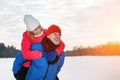 Smiling senior man giving mature woman piggyback in snowy winter park Royalty Free Stock Photo