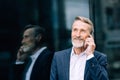 Smiling senior man making call outdoors