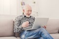 Smiling senior man reading news on laptop Royalty Free Stock Photo