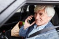 Smiling senior man speaking by phone and driving car Royalty Free Stock Photo
