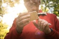 Senior man in sports clothing standing in forest and usi Royalty Free Stock Photo