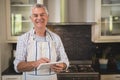 Smiling senior man using digital tablet in kitchen at home Royalty Free Stock Photo