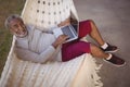 Smiling senior man using laptop while relaxing on hammock Royalty Free Stock Photo