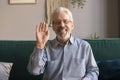 Smiling senior man wave at camera talking on video call Royalty Free Stock Photo