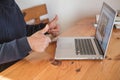 Smiling senior man  wave to camera having video call on laptop, happy elderly male  sit  at home talk using modern technologies Royalty Free Stock Photo