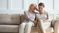 Smiling senior mom and daughter watch funny video on cell Royalty Free Stock Photo