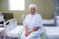 Smiling senior patient sitting on bed in hospital Royalty Free Stock Photo