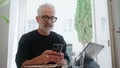 Smiling senior texting smartphone in cafe closeup. Successful bearded man browse Royalty Free Stock Photo