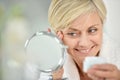 Smiling senior woman applying anti-aging cream Royalty Free Stock Photo