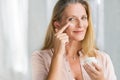 Woman applying anti aging lotion on face Royalty Free Stock Photo
