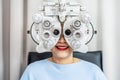 Smiling senior woman asian doing eye test on optical phoropter, checking on her eye with optometry machine Royalty Free Stock Photo