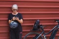 Smiling senior woman cyclist in outdoor excursion in urban city using mobile phone, ejoying healthy lifestyle Royalty Free Stock Photo