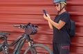 Smiling senior woman cyclist in outdoor excursion in urban city using mobile phone, ejoying healthy lifestyle Royalty Free Stock Photo