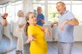 Smiling senior woman dancing twist with man in dance studio Royalty Free Stock Photo