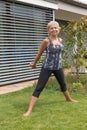 Smiling senior woman is exercising with dumbbells in an upright Royalty Free Stock Photo