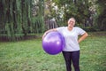 Smiling senior woman with fitness balls in park