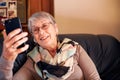 Smiling Senior Woman At Home Making Video Call To Family On Mobile Phone Royalty Free Stock Photo