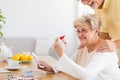 Smiling senior woman looking at container with hypertension drug