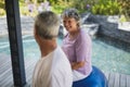 Smiling senior woman looking at man while sitting on exercise ball Royalty Free Stock Photo