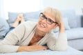 Smiling senior woman lying on couch Royalty Free Stock Photo