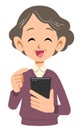 Smiling senior woman operating mobile phone