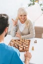 smiling senior woman playing chess with young male Royalty Free Stock Photo