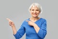 Smiling senior woman pointing fingers to something Royalty Free Stock Photo