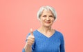 Smiling senior woman r showing thumbs up over pink Royalty Free Stock Photo