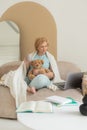 Smiling senior woman relaxing in home bedroom using laptop watching video or movie enjoying technology, leisure time, retirement